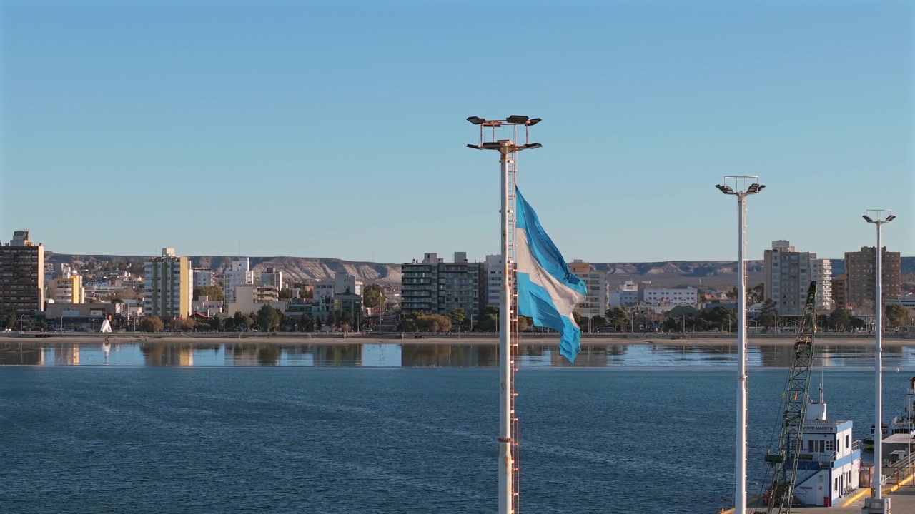 Images de drone du drapeau argentin flottant au-dessus du front de mer de Puerto Madryn à Chubut, Patagonie, Argentine.