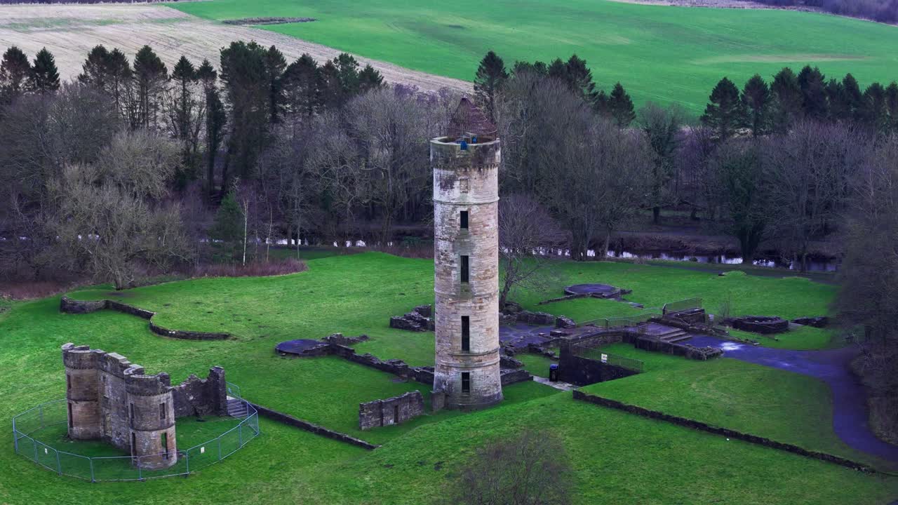 Historiske slotsruiner, parklandskaber, Eglinton Kilwinning, Skotland, filmisk luftperspektiv med dolly-bevægelse.