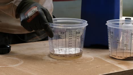 pouring polyester resin into a measuring cup