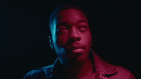 young black man dancing in neon lights