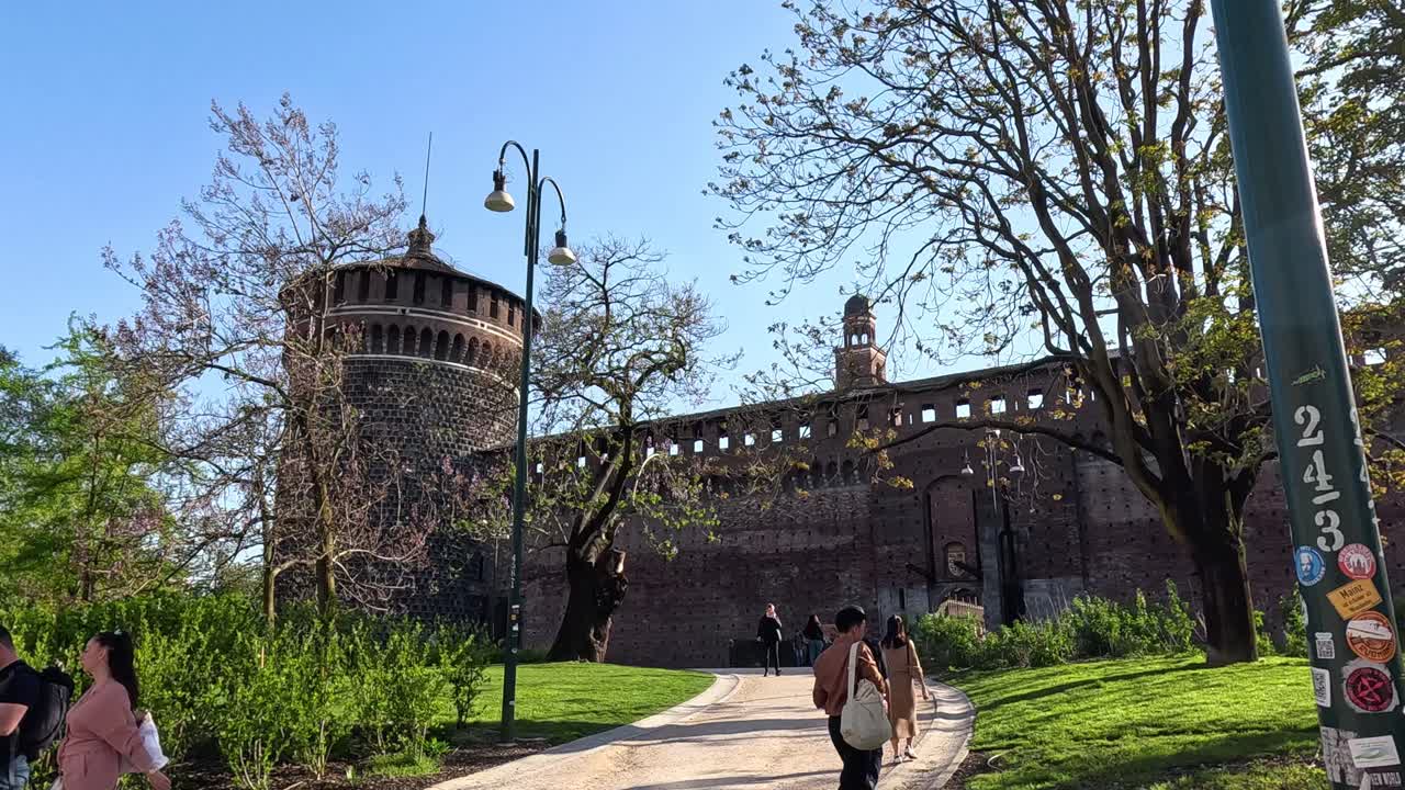 밀라노의 스포르제스코 성 근처에서 산책하는 사람들