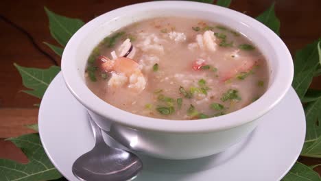 an asian bowl of delicious rice soup with prawns and shrimp