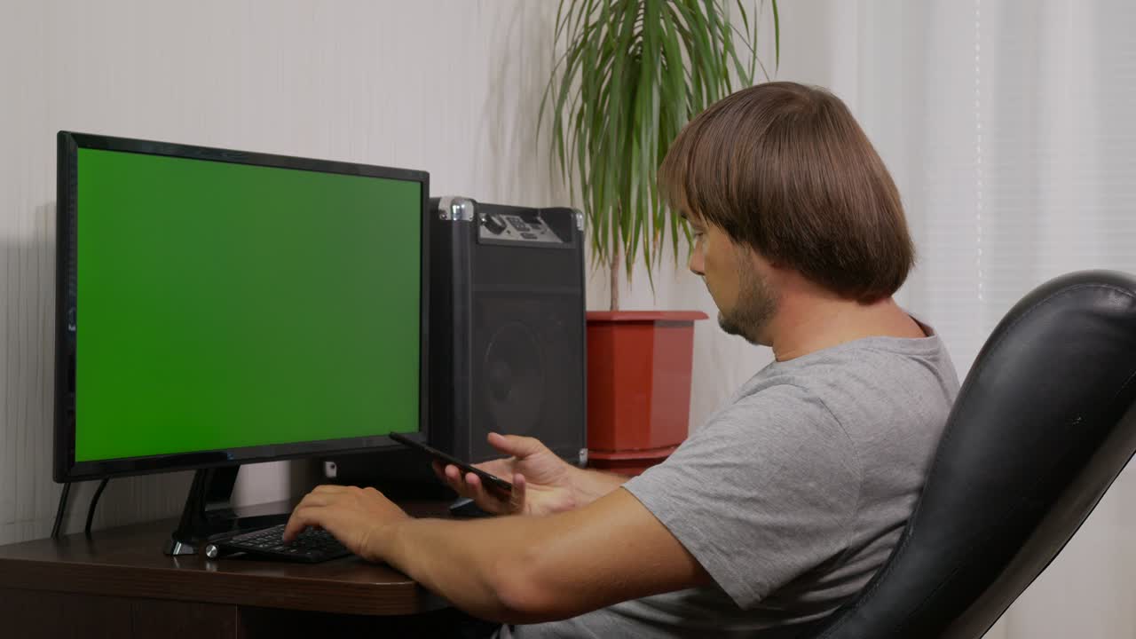 de un hombre escribiendo en el teclado de la computadora portátil con pantalla verde, trabajando desde casa, persona de la oficina en el hogar usando una computadora portatil con pantalla verde de la llave de croma.