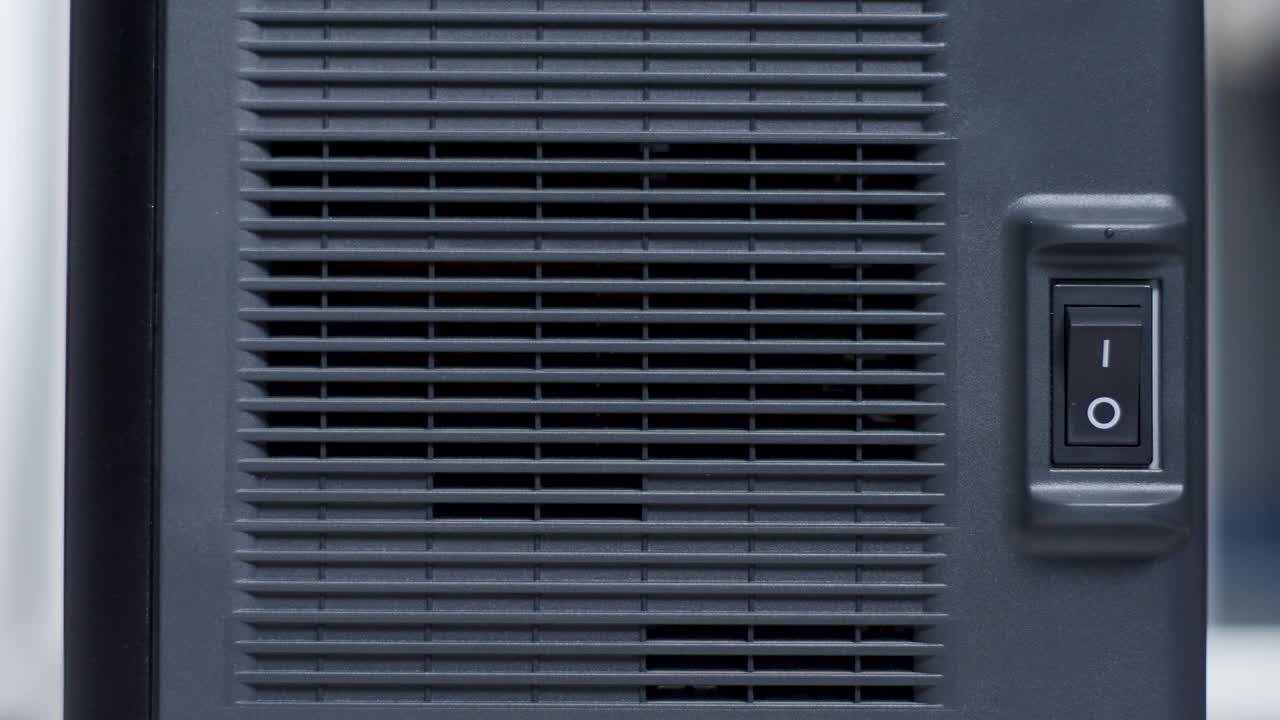 En persons finger trykker på og av en svart plastknapp
