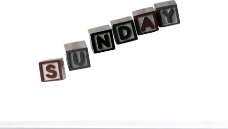 sunday spelled out in letter blocks falling over