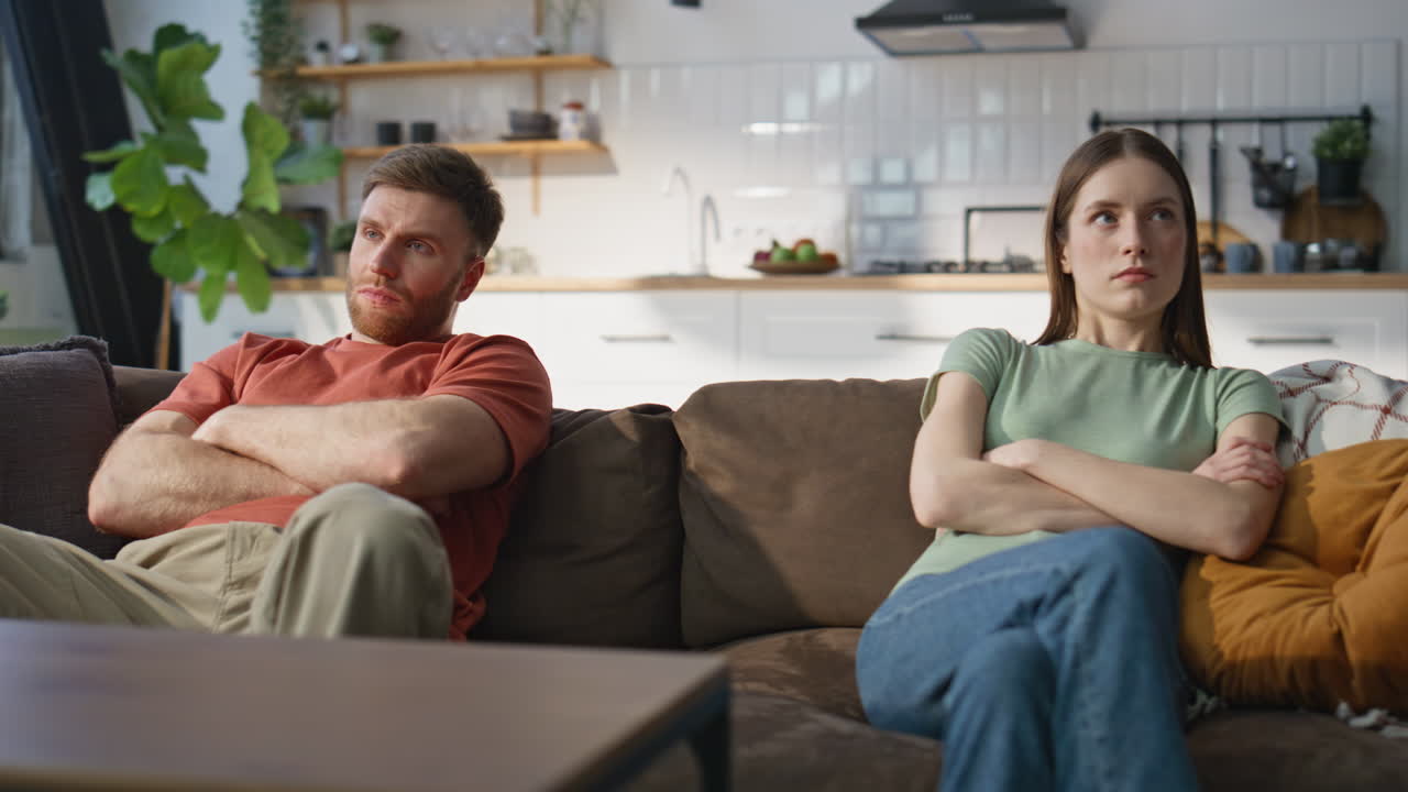 Married couple resent sitting separately home couch closeup. Frustrated partners