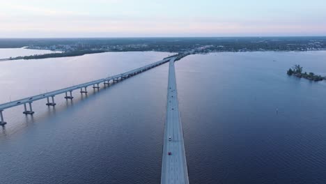 Toma-Aérea-Que-Establece-El-Tráfico-En-Puentes-En-Fort-Myers-Durante-La-Hora-Azul-Después-Del-Atardecer-En-La-Noche---Toma-Panorámica