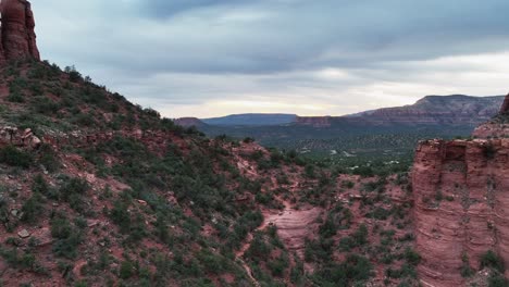 Volando-En-Las-Montañas-Rojas-De-Sedona-Y-El-Bosque-Con-La-Ciudad-Rural-Durante-La-Puesta-De-Sol-En-Arizona,-Estados-Unidos