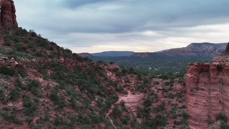 flying on sedona red mountains and forest with rural town during sunset in arizona, usa