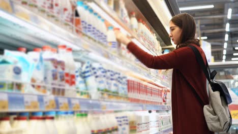 woman shopping for milk in a grocery store