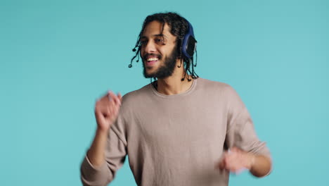 joyous man listening music, having fun, dancing, studio background