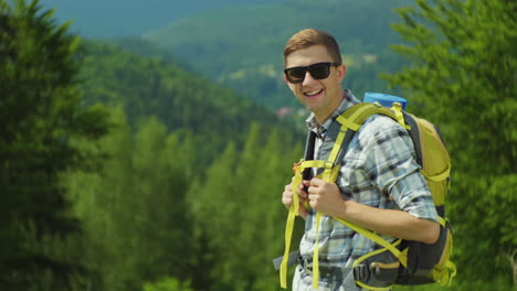 portrait of a young attractive tourist man he is wearing a yellow backpack looking at the camera smi