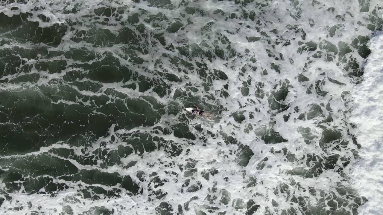 공중 - 서퍼가 파도를 잡으면 서 카메라가 뒤로 당깁니다.