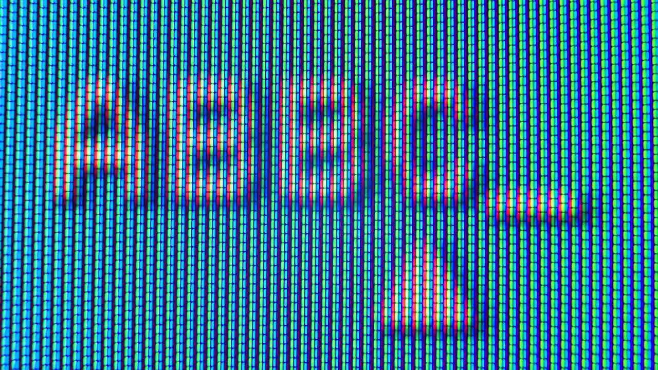 Pixels in the working old analog TV screen close up. Red, blue and green dot create the image on the screen. Analogue retro TV settings menu in extreme close up