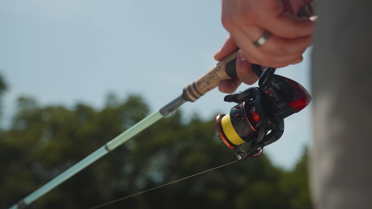 Spinnfiske i soligt väder med handtag i korkträ på klassiskt fiskespö med fiskare som jagar fisk och mat (4K30p)