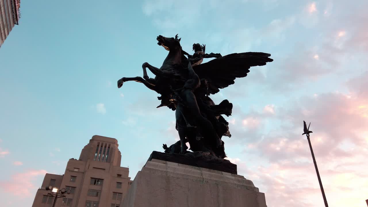 Handheld shot from the ground of statue and cityscape during the day in a mexican city, wide shot
