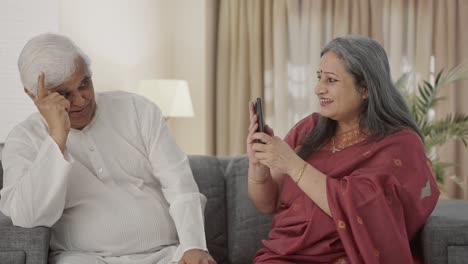 vieja esposa india feliz haciendo clic en la foto de su marido