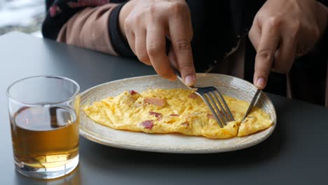 mujer comiendo una deliciosa tortilla de desayuno