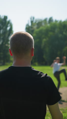 un hombre de mediana edad le lanza una pelota a su hijo durante una animada sesión de fútbol al aire libre, el hijo hábilmente patea la pelota para su abuelo, quien patea la bola lejos