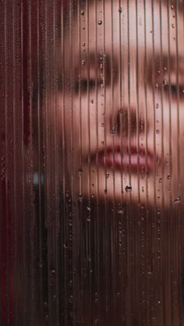 woman's face behind a textured glass