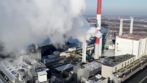 the smoking and steaming chimneys of the heat and power plant in warsaw, poland