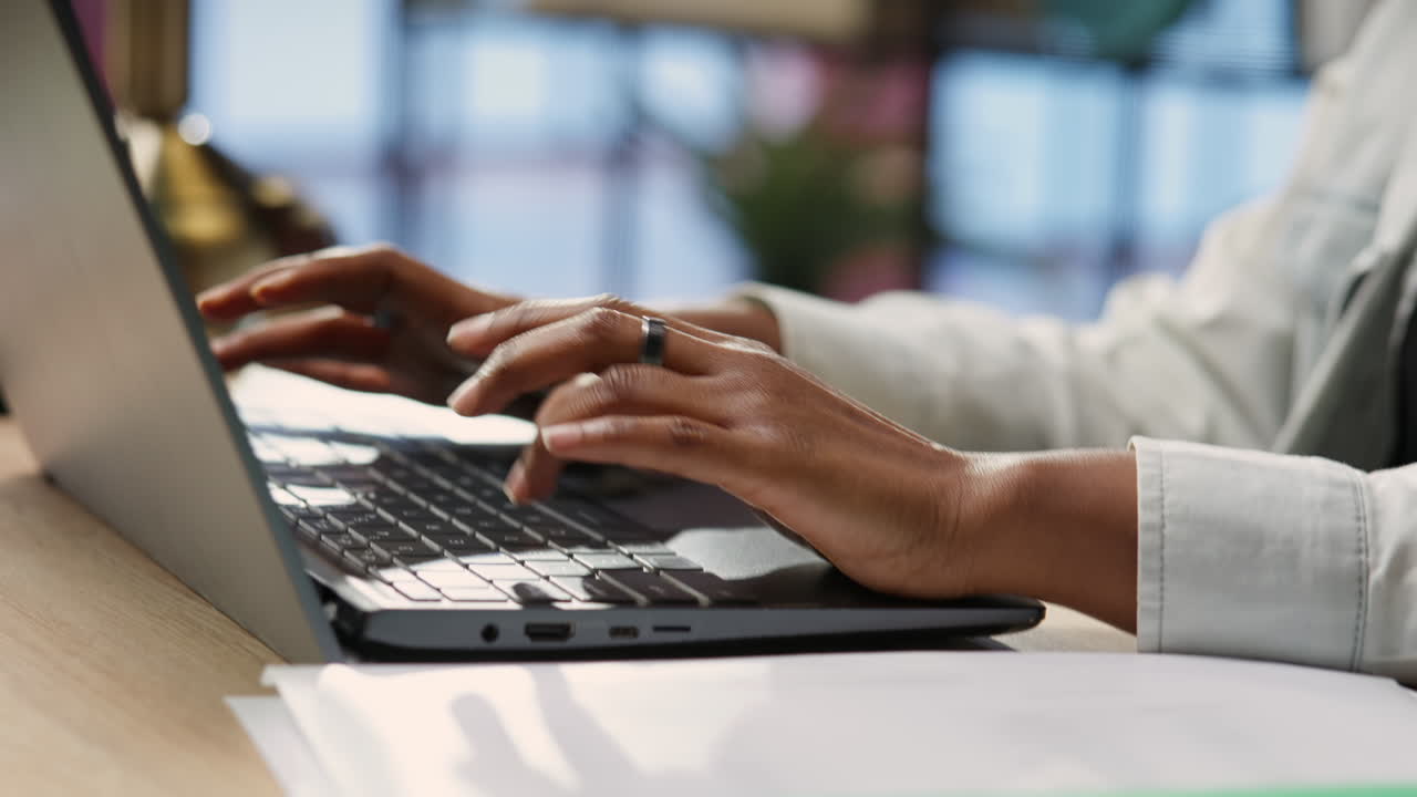 Freelancer in home office typing on laptop keyboard, close up