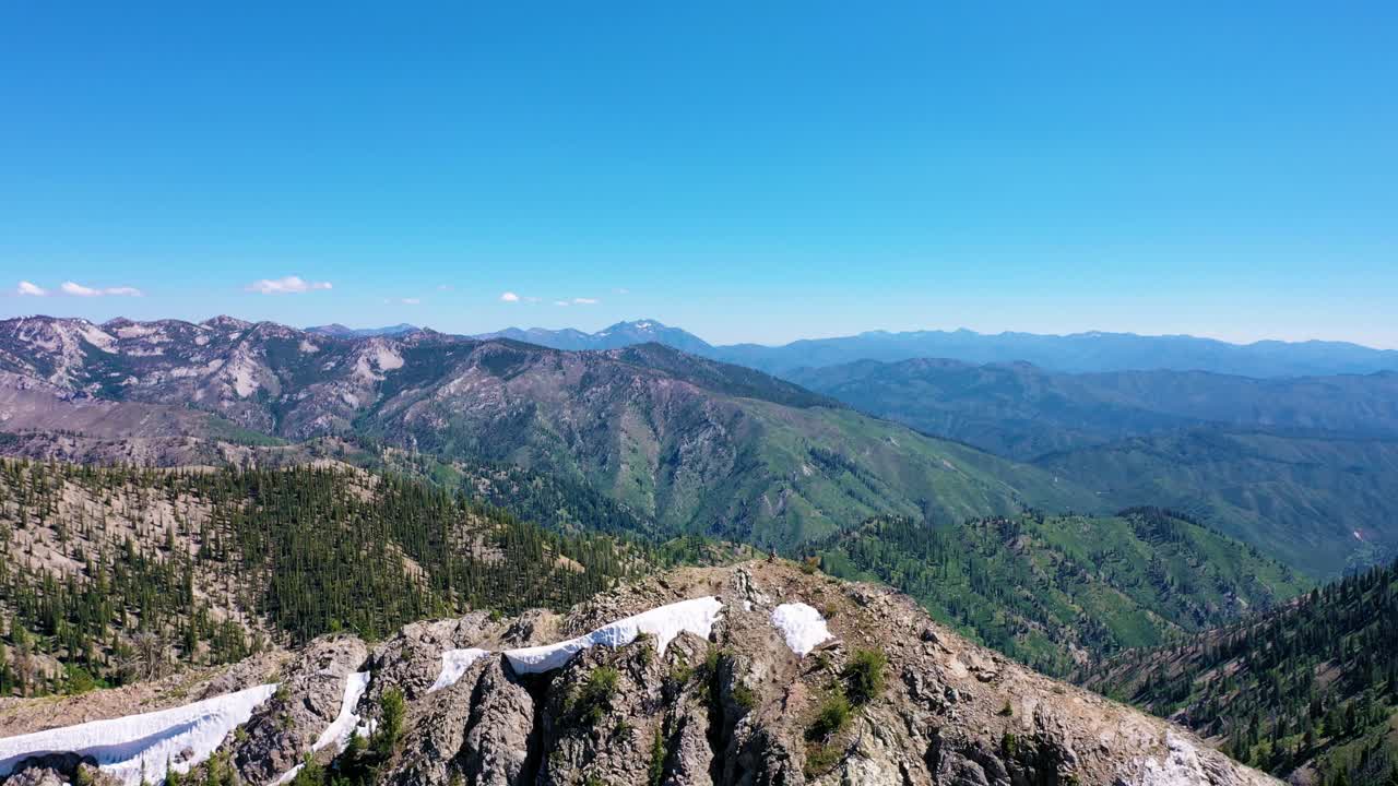 disparo aéreo de avión no tripulado se saca de una vista nevada de la cordillera que revela un hermoso bosque y un lago de campo