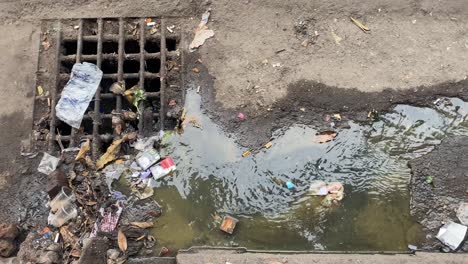 Schmutziges-Wasser,-Das-Am-Müll-Vorbei-In-Das-Regenabflusssystem-Fließt