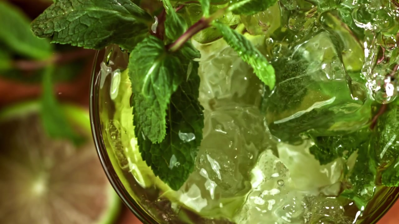 Cubetti di ghiaccio in super rallentatore che schizzano in un rinfrescante cocktail Mojito