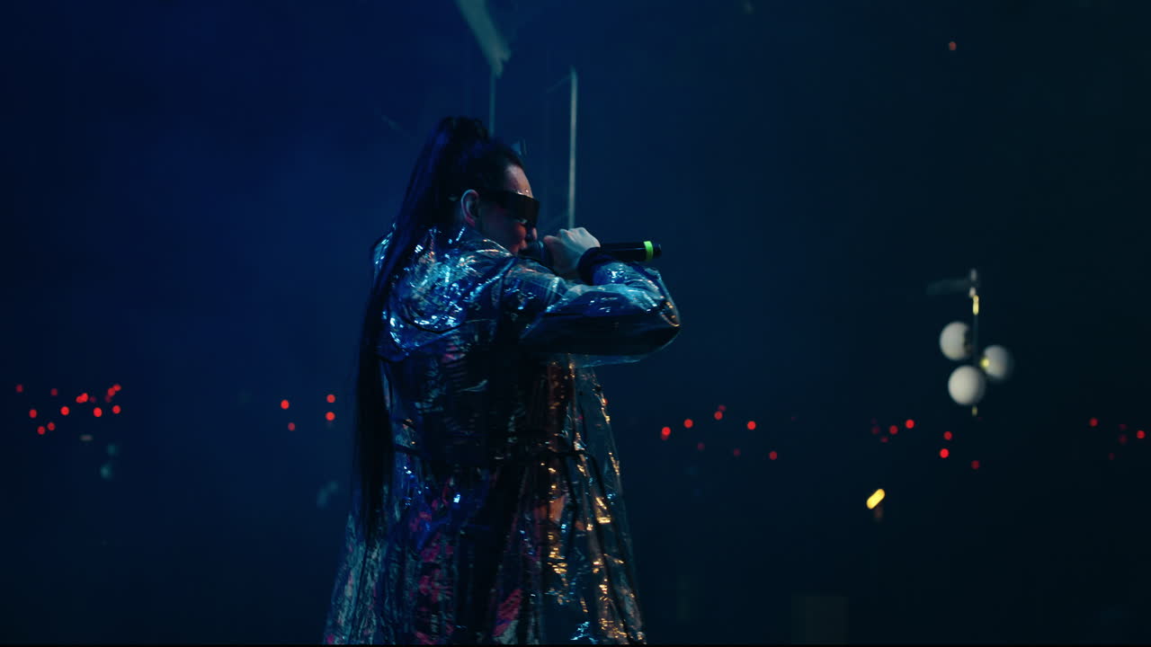 mujer cantando en el escenario en un concierto