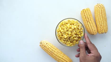 chopped corn in glass bowl with corn cob