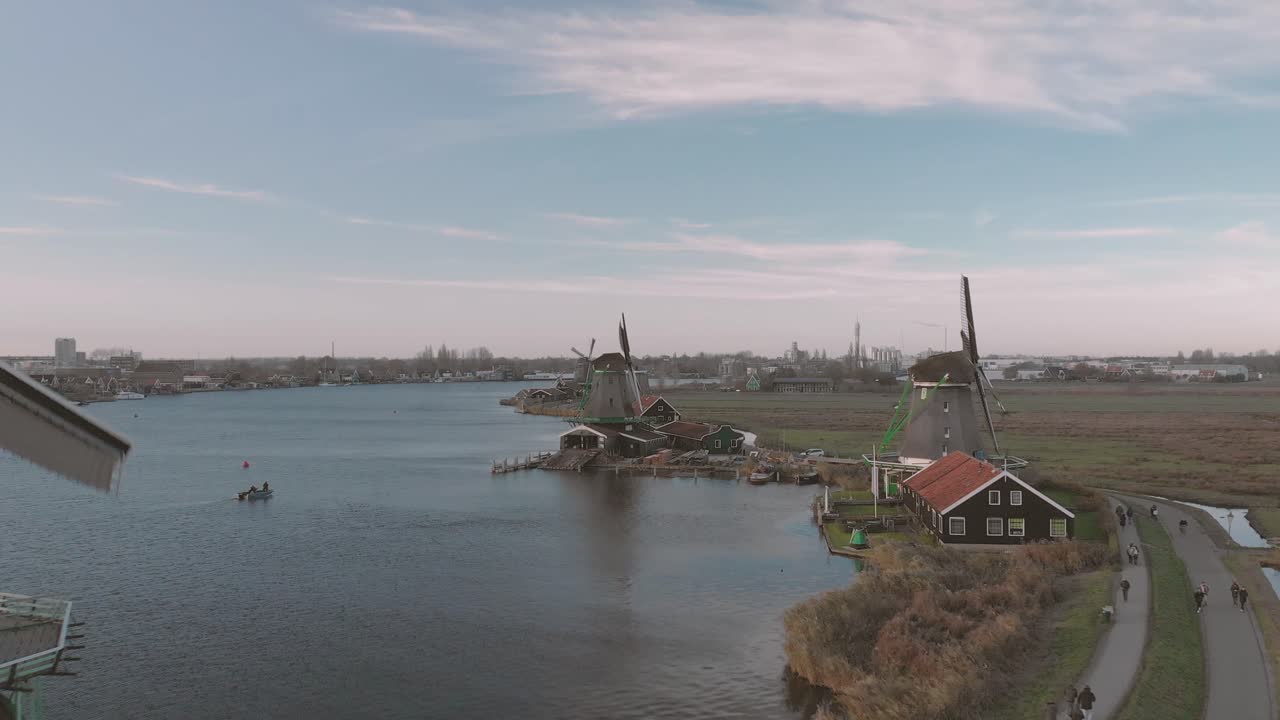 푸른 하늘이 있는 밝은 날에 심지가 회전하는 전형적인 네덜란드 풍경의 풍차에 대한 공중 전망