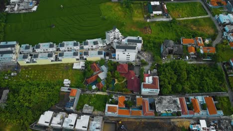 Cinematic-drone-footage-of-Berawa-beach-in-Canggu,-Bali-with-beautiful-landscape,-expensive-hotels,-rice-fields-and-villas-through-calm-weather