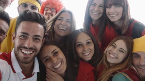 un grupo de aficionados al deporte tomando selfies, filmados en cámara lenta.