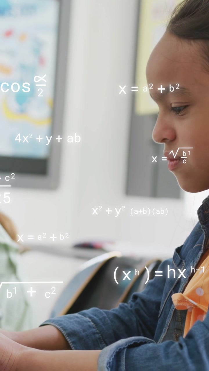 Vertical video: Girl studying tablet in class, tapping, writing, causing math symbols filling frame