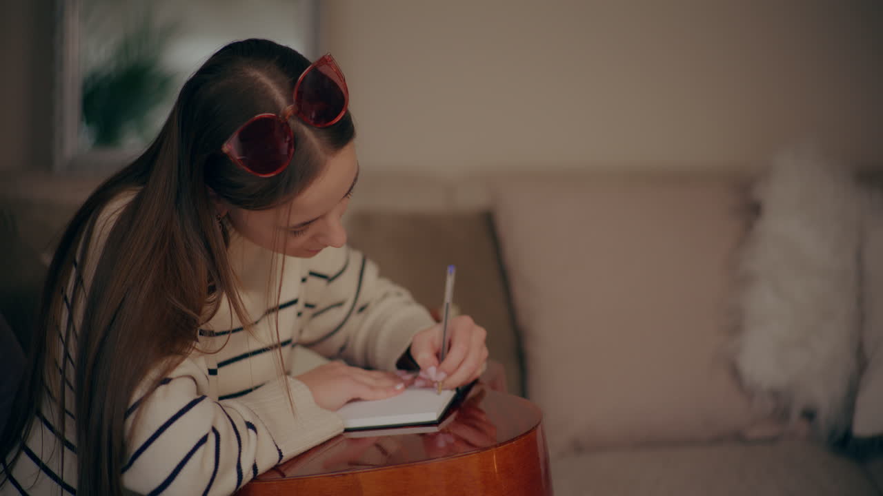 Donna che suona la chitarra, scrive e compone musica