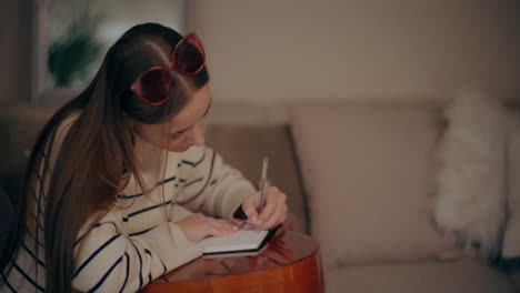 woman playing guitar writing song composing music