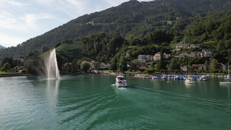 Drone following a ferry pulling into the marina of a resort in the mountains