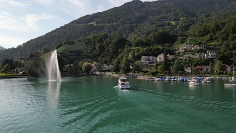 Drohne-Folgt-Einer-Fähre,-Die-In-Den-Yachthafen-Eines-Resorts-In-Den-Bergen-Einfährt