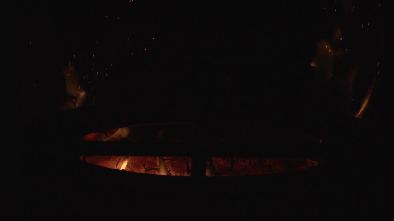 Log burning stove with natural flame and sparks. Closeup shot