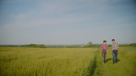 two farmers talk about crops against agricultural landscape