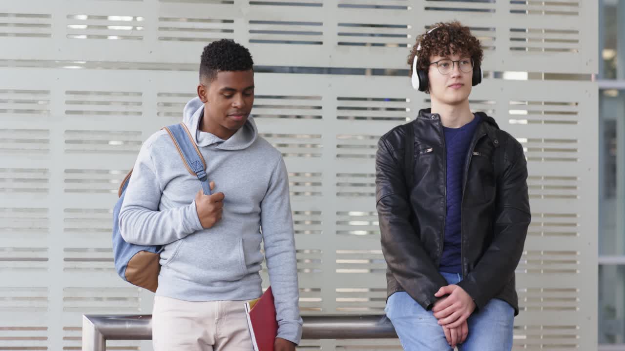 Diversos passageiros do sexo masculino desviando o olhar e ouvindo música na plataforma após a entrada de um novo passageiro