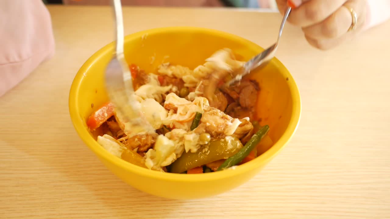 손과 도구로 혼합 된 요리를 먹는 것