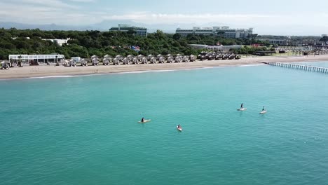 Paddlers-enjoying-crystal-clear-water-and-beautiful-resort-on-sunny-day