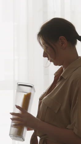 woman holding a container of pasta