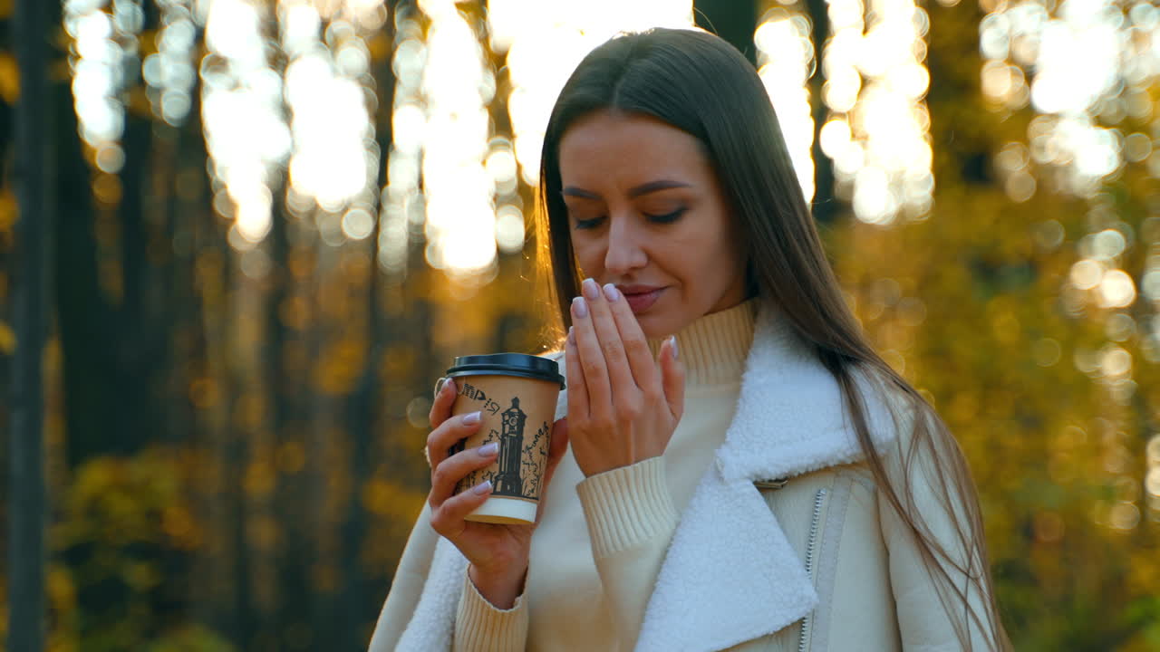 Mujer disfrutando de un café en un parque de otoño