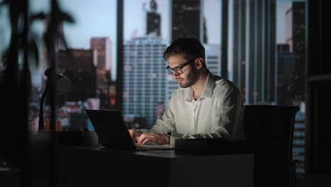 Porträt-Eines-Nachdenklichen,-Erfolgreichen-Geschäftsmannes,-Der-Nachts-In-Seinem-Großstadtbüro-Am-Laptop-Computer-Arbeitet.-Der-Charismatische-Digitale-Unternehmer-Führt-Datenanalysen-Für-Die-E-Commerce-Strategie-Durch