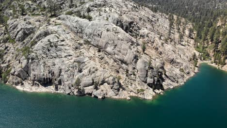 Toma-Aérea-Giratoria-De-Una-Gran-Losa-De-Granito-En-El-Borde-De-Un-Lago-De-Alta-Sierra-En-California