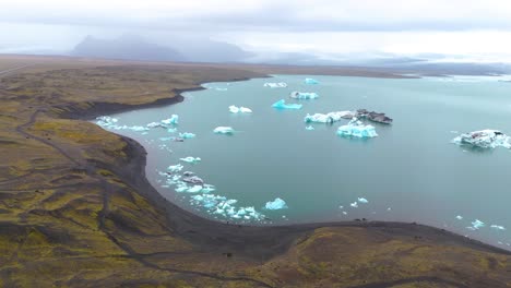 aerial view of a glacial lake with ice and scenic mountain landscape in iceland