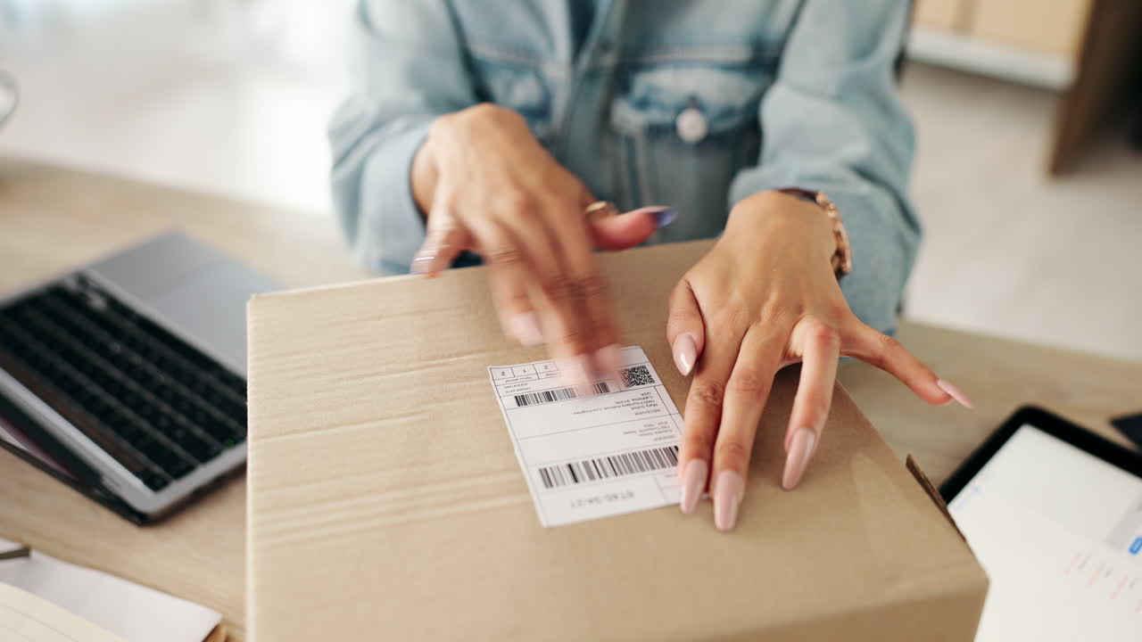 Woman attaching a shipping label to a package